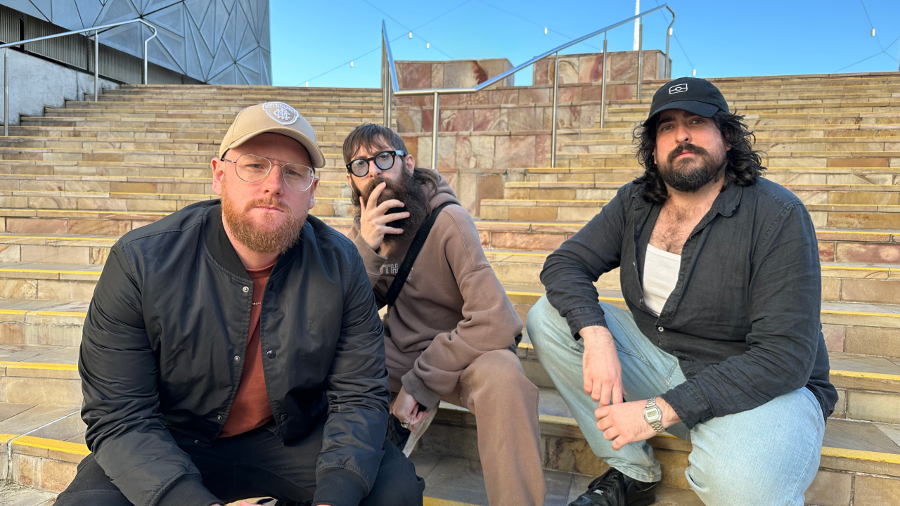 Aunty Donna squatting on a set of stairs in Federation Square in Melbourne.